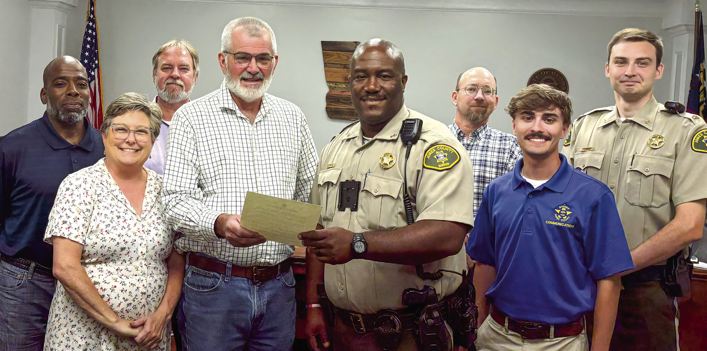 Chairman Chris Weidner hands the proclamation in honor of the Jones County Sheriff’s Office to Lt. Travis Walker, who was joined by Dispatcher Devin Comer (in blue) and Cpl. Christopher Stewart, who works in the jail. DEBBIE LURIE-SMITH/Staff