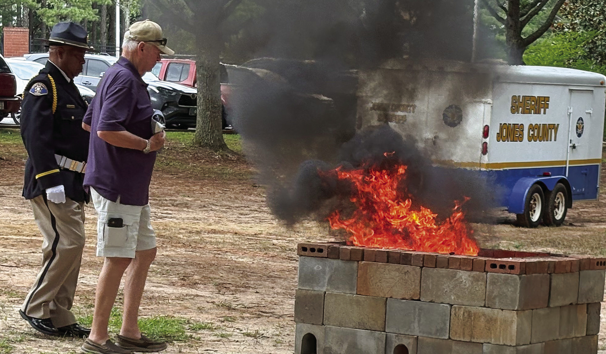 Jones County veteran Frank Duke — escorted by JCSO Deputy Sgt. Boisey Hunt — carry a folded flag to the fire pit during the June 15 flag retirement ceremony. DEBBIE LURIE-SMITH/Staff