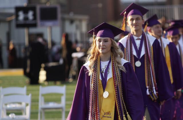 Valedictorian Ariana Epps and Salutatorian Aaron Varnadoe lead the processional at Jones County High School’s 2026 graduation ceremony that was held on the football field. The ceremony had been held in Milledgeville at Georgia College’s Centennial Center for the past several years. BRAD HARRISON/Staff