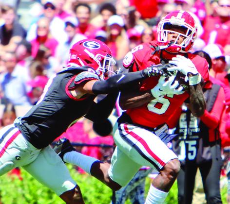 Georgia wide receiver Dominic Lovett (6) makes an over-the-shoulder catch over a defender. LANCE McCURLEY/Staff