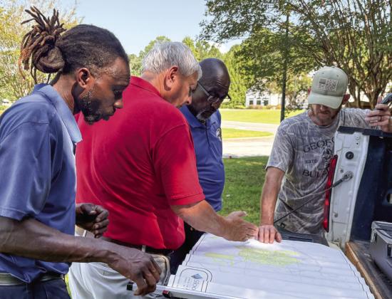 Georgia Rural Water and Gray Water Department officials look at a map of Gray’s 70 miles of water lines while looking for a solution last week. DEBBIE LURIE-SMITH/Staff