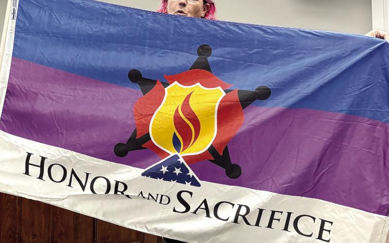 Emma Warren displays the “Honor and Remember” and “Honor and Sacrifice” flags with a request they be purchased and flown in Jones County. DEBBIE LURIE-SMITH/Staff