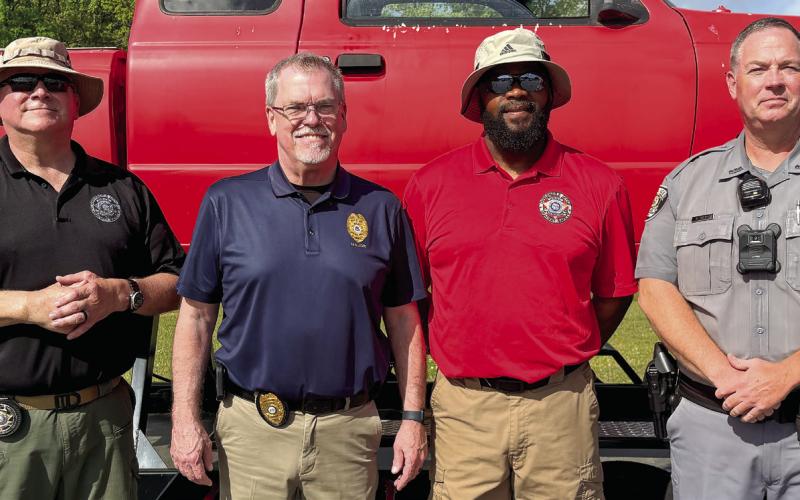 GOHS Officer Cam Reed, GPD Maj. Mark Robinson, GOHS Officer Donnie Winfield and GPD Officer Henry Thayer in front of the rollover simulator. DEBBIE LURIE-SMITH/Staff