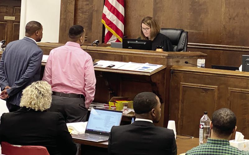 Cameren Banks (red shirt) and his attorney Melvin Raines II at the bench in front of Superior Court Judge Alison Burleson at the 2022 murder trial. FILE PHOTO
