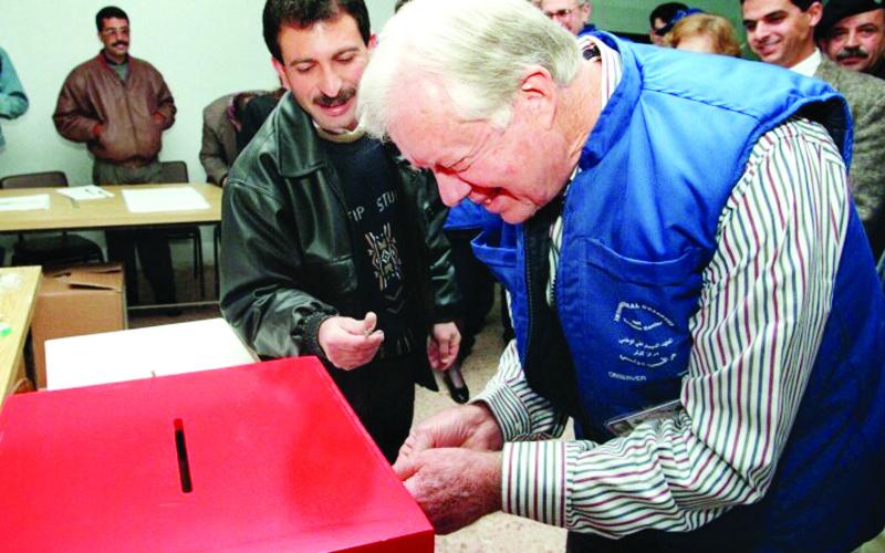 Former President Jimmy Carter votes at a ballot box. He monitored elections in more than 100 countries. CONTRIBUTED