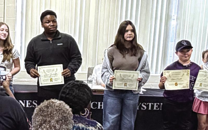 Winners of the Young Georgia Authors competition line up after their names were called at the April 13 meeting of the Board of Education. CONTRIBUTED