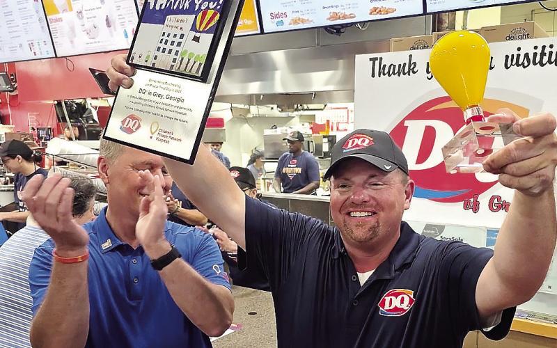 Kelly (right) with award as DQ CEO Troy Bader (left) applauds. CONTRIBUTED