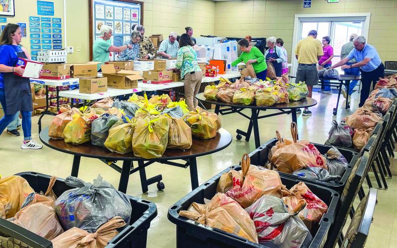 Volunteers with community ministries bag food, led by Hannah Foval (far left), to address access to food for students outside of the school day. CONTRIBUTED