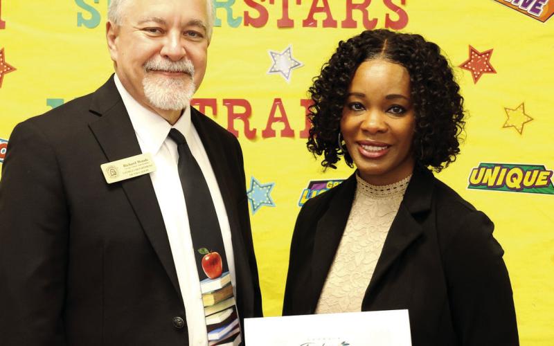 Above: Charm Mapp is surprised at a classroom visit by State School Superintendent Richard Woods. At left: Mapp and Woods with the state finalist notice. CONTRIBUTED PHOTOS