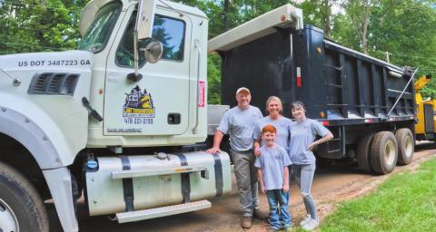 John McIntosh with his family in front of one of their trucks and other equipment used for JME Excavation. CONTRIBUTED BY JESSICA MCINTOSH