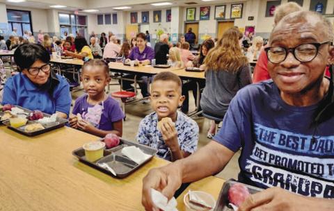Two students at Mattie Wells Elementary School with their grandparents during breakfast. CONTRIBUTED