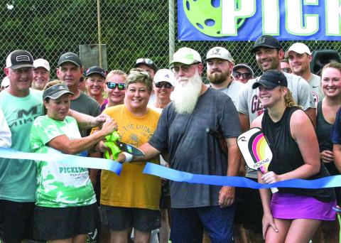Commissioner Wendy Vaughn (center, yellow shirt), surrounded by Michelle Craddock and Lynn Dugger, opened Jones County’s Pickle Ball courts Aug. 30 by cutting the ribbon. SEE FULL COVERAGE IN SPORTS >> PAGE C3 BRAD HARRISON/Staff