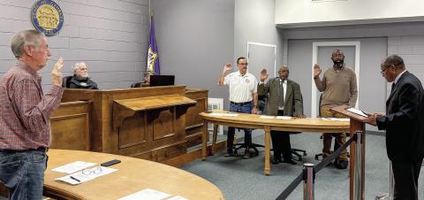 Probate Judge Lewis Patterson gives the oath of office to councilmen Terrell Fulford (left), Terry Favors (white shirt, then l-r), David Tufts and Ikea Simmons before the Jan. 5 council meeting. DEBBIE LURIE-SMITH/Staff