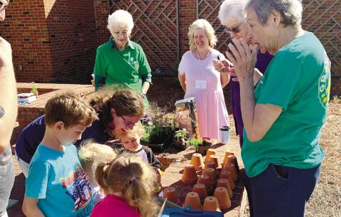Gray Garden Club members visit the Jones County Public Library during the Growing Greyhounds event, helping children plant plants. CONTRIBUTED