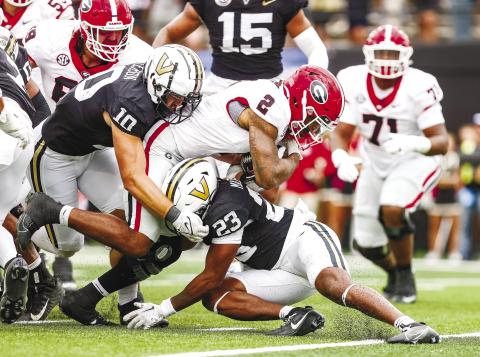 Georgia running back Kendall Milton (2) dives for extra yards as a pair of Vanderbilt defenders try and bring him down. TONY WALSH/UGA Athletics