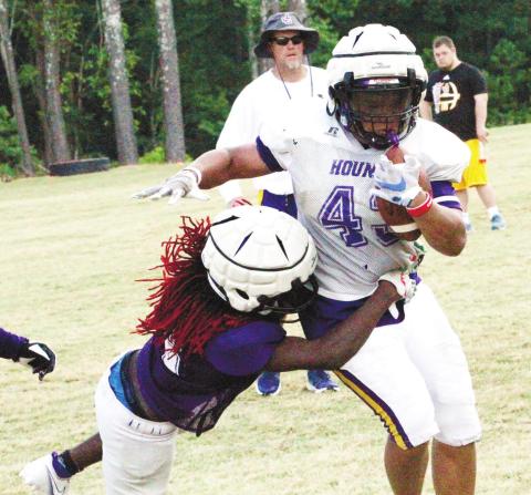 The Greyhounds offensive backs break through for a gain of yardage near the end of Monday’s practice. BRAD HARRISON/Staff