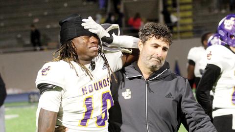 Greyhounds linebacker DJ Ingram, left, is consoled by defensive coordinator Will Conner as players and coaches leave the field after Friday’s loss to Marist. BRAD HARRISON/Staff