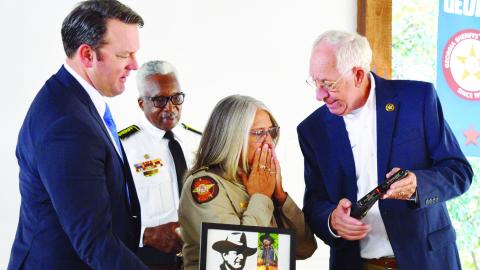 Sheriff Butch Reece (far right) presents Sheriff of the Year Janis Mangum (center) with a Glock that was specially engraved to mark the occasion in addition to the engraved signature of her hero, John Wayne. COURTESY OF JONES COUNTY SHERIFF’S OFFICE