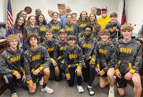 Runners and coaches from the Greyhounds and Lady Greyhounds cross country team pose after being recognized at a recent Jones County Board of Commissioners meeting. DEBBIE LURIE-SMITH/Staff