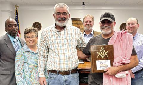 Public Works employee John Simmons (second from right) is presented with a plaque for his work on the county’s Christmas float by Chairman Chris Weidner surrounded by Jones County commissioners. DEBBIE LURIE-SMITH/Staff