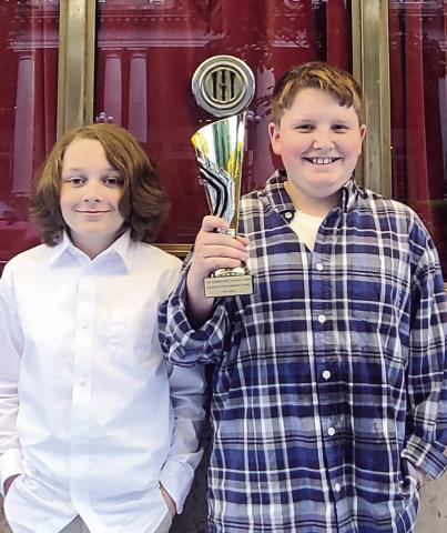 Keagan Stafford and Rayden Faulk hold up their award for the stock market game at the Atlanta Fox Theatre. CONTRIBUTED