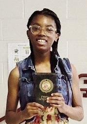 Former Mattie Wells Elementary School student, Jamaya Brown, walking with her award she received after missing zero days of school from kindergarten through fifth grade. CONTRIBUTED