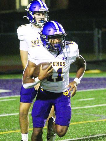 Travis Miller (11) takes the handoff from Cason Taylor to pick up yardage during Friday’s win at Hampton. BRAD HARRISON/Staff