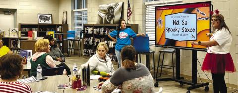 Gracie Cummings, first grade teacher, presenting slides during the Not So Spooky Saxon event.