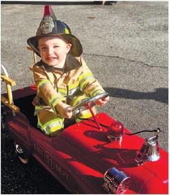 Mitch Morrison and Slayden Hardee with the pedal car fire truck at Main Street Gray.