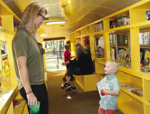 A child at Touch-A-Truck picks out a book from Jones County’s literacy bus, Little Jo. NATHAN CLARKE/Contributed