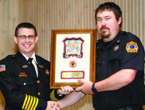 Brandon Perry (right) is named Firefighter of the Year by Chief Keith Eisele. CONTRIBUTED