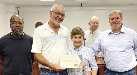 Dames Ferry Elementary student Achilles Woodson receives a certificate of excellence from Jones County Commission Chairman Chris Weidner June 6 in recognition of being a Science Olympiad winner. DEBBIE LURIESMITH/STAFF