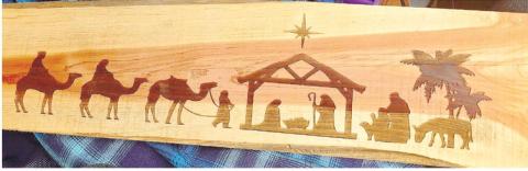 A piece of wood with a nativity scene engraved into the wood to be displayed for people to see. CONTRIBUTED