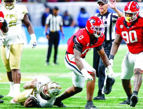 Georgia edge rusher Gabe Harris Jr. (0) celebrates after tackling Georgia Tech quarterback Haynes King for a loss. LANCE McCURLEY/Staff
