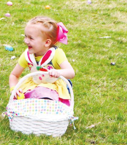 One of the young participants at the Easter egg hunt held at First Baptist Church enjoys filling up her basket. NATHAN CLARKE/Contributed