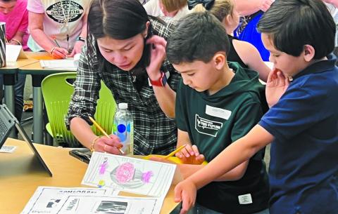 A student and his family go through the research paper together at Turner Woods Elementary School. ALAINA CLARKE/Staff