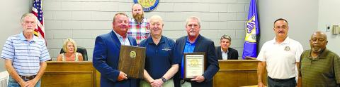 Chuck Groover of the Georgia Association of Chiefs of Police (center) after presenting Gray Police Chief Adam Lowe (center left) and GPD Sgt. Mark Robinson with plaques commemorating the achievement of State Certification of the Gray Police Department. DEBBIE LURIE-SMITH/Staff