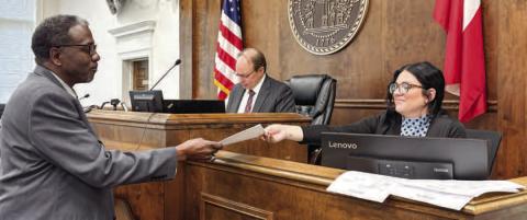 Bailiff James Bland (left) hands court paperwork to Clerk Julia Oxford during a Superior Court session April 3 with presiding Superior Court Judge Stephen Bradley. DEBBIE LURIE-SMITH/Staff