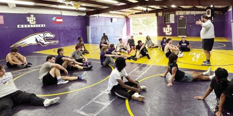 Greyhounds head wrestling coach Adam Gillhouse addresses the team near the end of Monday afternoon’s first practice of the season. BRAD HARRISON/Staff