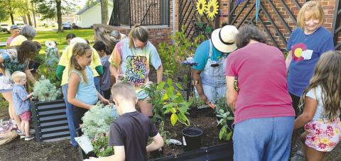 Last week’s Summer Reading Program became hands-on, assisting with the planting of raised beds at the library. Contributed