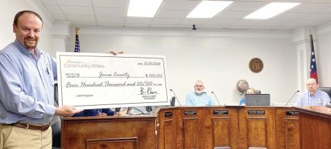 County Administrator Jason Rizner displays the check from the Georgia Department of Community Affairs for the CHIP Grant. DEBBIE LURIE-SMITH/Staff