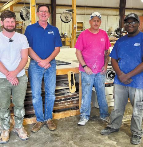 Randy Smith (blue shirt in middle) takes a photo with his employees at Cabinet Resources as they work on various renovation projects.
