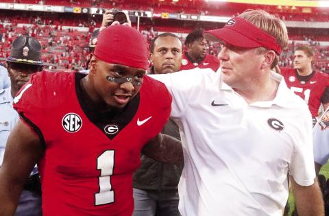 Georgia running back Trevor Etienne (left) shares a moment with head coach Kirby Smart (right) after the Bulldogs’ 31-13 win over Auburn. LANCE McCURLEY/Staff