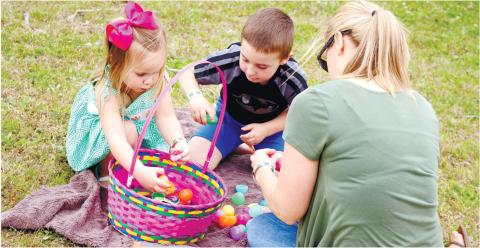 Children open their eggs after a previous egg hunt. CONTRIBUTED