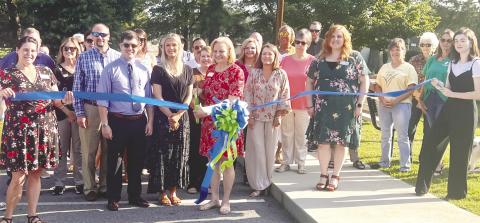 Julie King, branch manager of the Jones County Library, along with library staff, cutting the ribbon for the opening of library park. ALAINA CLARKE/Staff