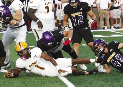 The Greyhound defense closes in to make a tackle behind the line of scrimmage against Perry. BRAD HARRISON/Staff