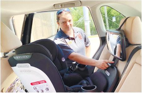Gray Fire Department Capt. Heather Johnson, a certified car seat tech, inspects the car seat in this reporter’s car, pointing out the importance of a secure anchor. DEBBIE LURIE-SMITH/Staff
