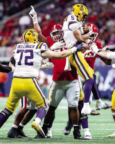 Georgia defensive lineman Jalen Carter (88) sacks LSU quarterback Jadyn Daniels (5) while lifting him in the air, ensuring a soft landing for the injured signal caller. Carter ended the game with four tackles, one sack, two tackles for loss and one pass deflection. TONY WALSH/UGA Athletics