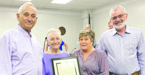Bobby and Joyce Coulter (l-r) display their proclamation in appreciation of decades of service with Commissioner Wendy Vaughn and Chairman Chris Weidner. DEBBIE LURIE-SMITH/Staff