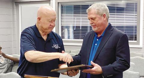 GACP Certification Coordinator Chuck Groover (left) congratulates Gray Police Sgt. Mark Robinson, who served as the certification manager for GPD, following the June 5 announcement of the department’s state certification. DEBBIE LURIESMITH/Staff